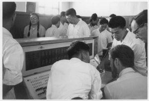 Wes Clark (sitting), Herbert Simon (right) and Severo Ornstein (background) meeting with Chinese computer experts in 1972.